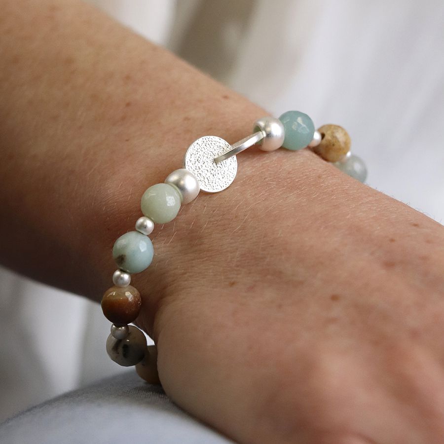 Pale natural stone bracelet with connected silver plated discs