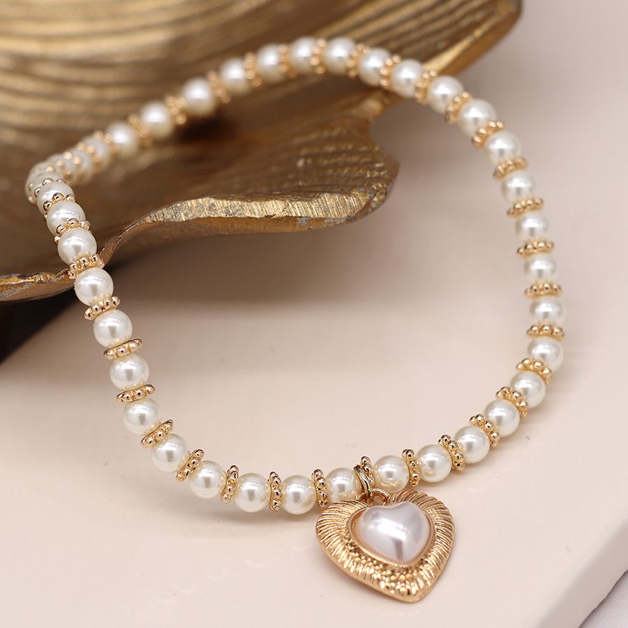 Ivory pearl and golden spacer bracelet with heart charm