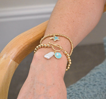 Golden whale tail and blue starfish charm bracelet