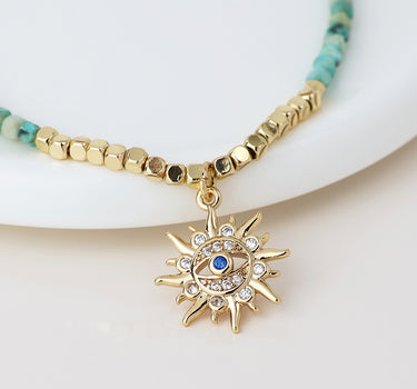 Golden and turquoise bracelet with crystal sun charm
